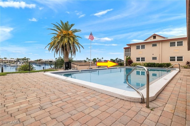 view of pool with a patio area and a water view