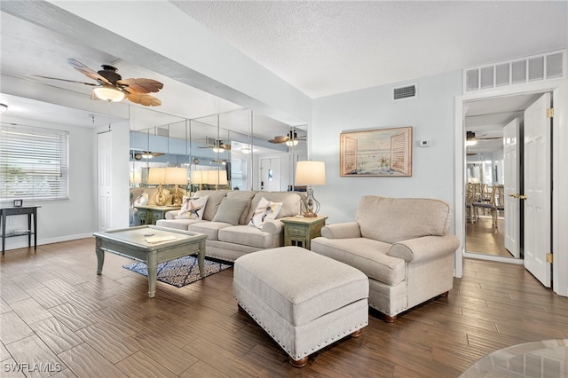 living room with ceiling fan and a textured ceiling