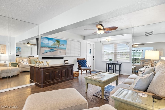 living room with ceiling fan, dark wood-type flooring, and a textured ceiling