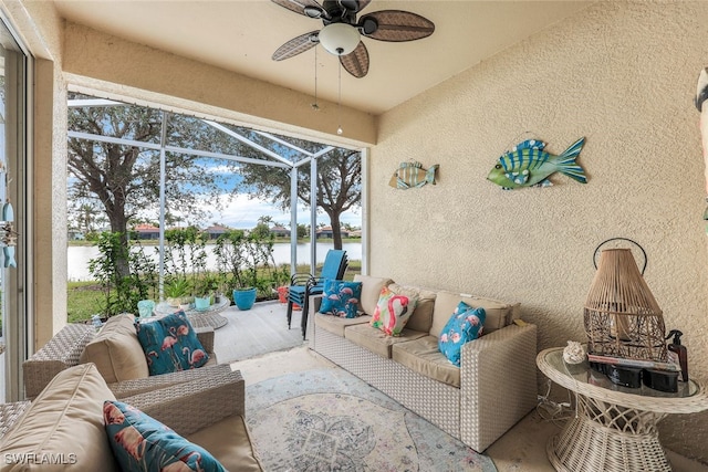 sunroom / solarium featuring ceiling fan and a water view