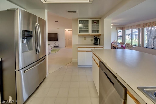 kitchen with white cabinetry, light carpet, appliances with stainless steel finishes, ceiling fan, and backsplash