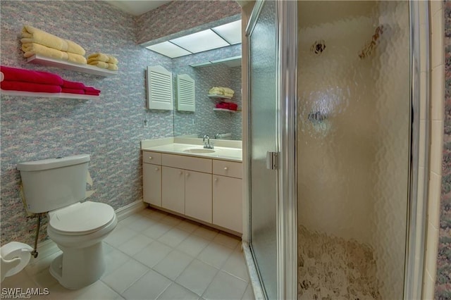 bathroom with vanity, a shower with door, and toilet