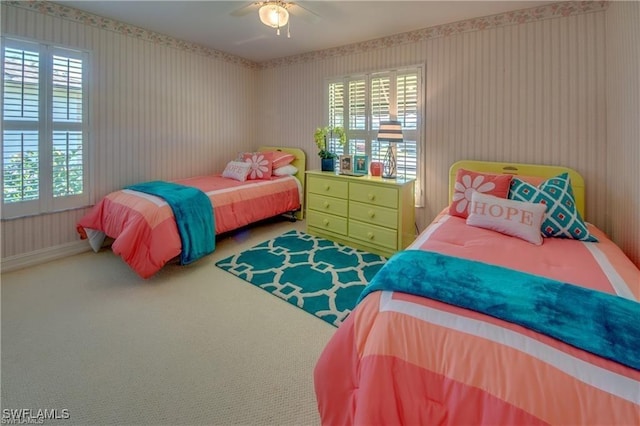 carpeted bedroom featuring multiple windows and ceiling fan