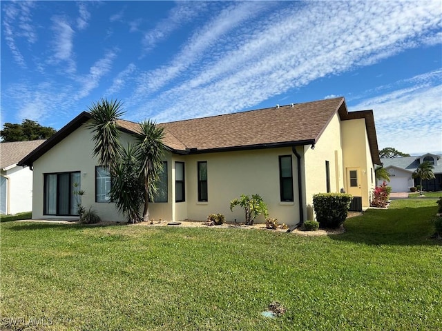 back of property with a lawn and central air condition unit