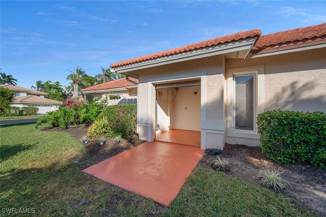 property entrance with a lawn