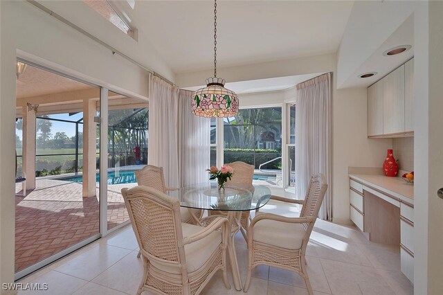 dining room featuring lofted ceiling, light tile patterned floors, and a wealth of natural light