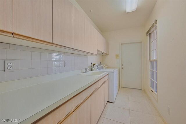 laundry room with cabinets, separate washer and dryer, sink, and light tile patterned floors