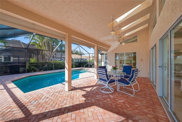 view of swimming pool featuring a patio area and glass enclosure