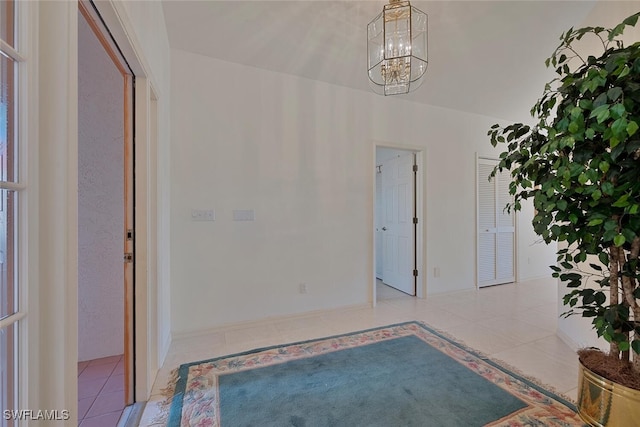 foyer with tile patterned flooring and a chandelier