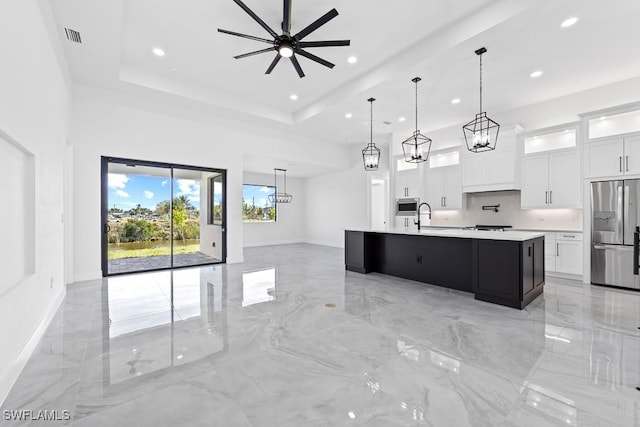 kitchen featuring pendant lighting, a center island with sink, white cabinets, and appliances with stainless steel finishes