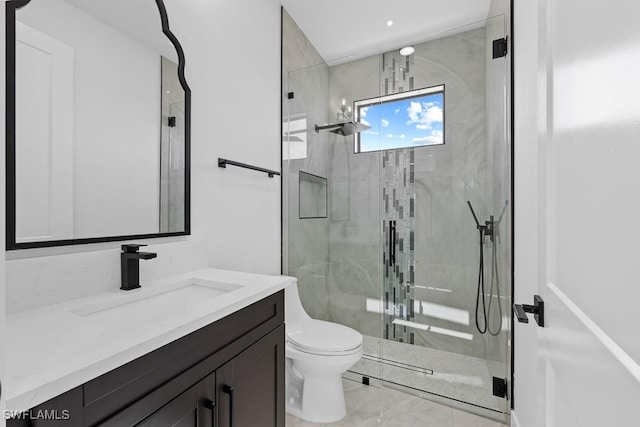 bathroom featuring vanity, toilet, and a shower with door