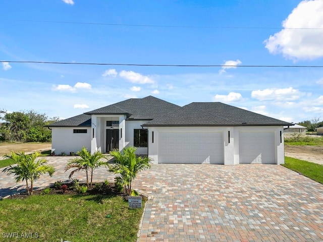 prairie-style house featuring a garage and a front yard