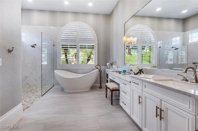 bathroom featuring vanity, a wealth of natural light, and plus walk in shower