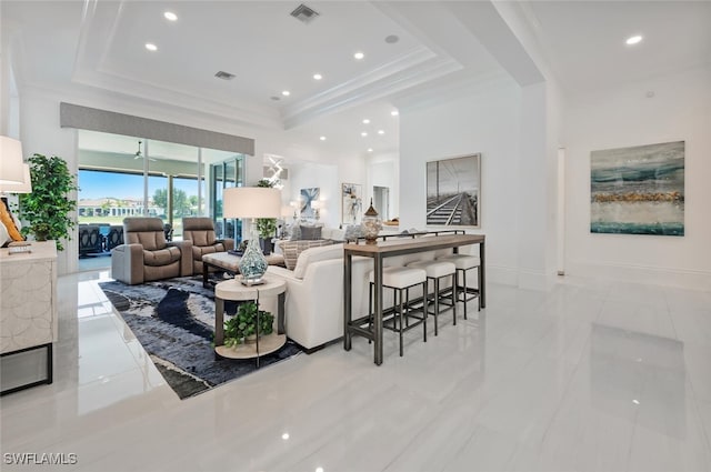 living room with a raised ceiling and light tile patterned floors