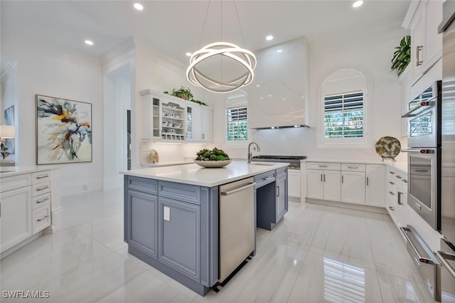 kitchen with dishwasher, hanging light fixtures, ventilation hood, an island with sink, and white cabinets