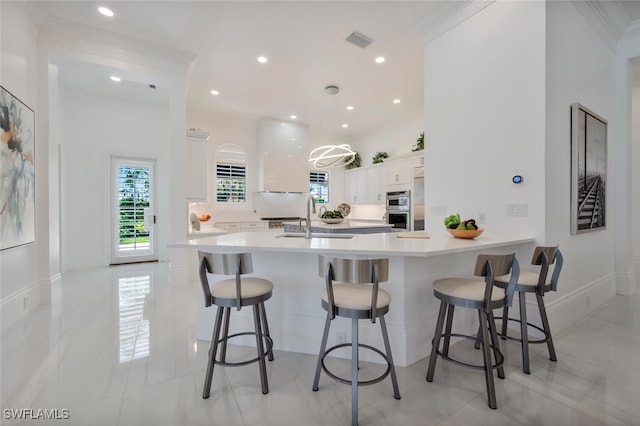 kitchen featuring white cabinetry, sink, a breakfast bar area, and kitchen peninsula