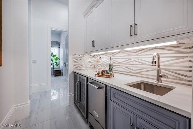 kitchen with sink, decorative backsplash, stainless steel dishwasher, and white cabinets