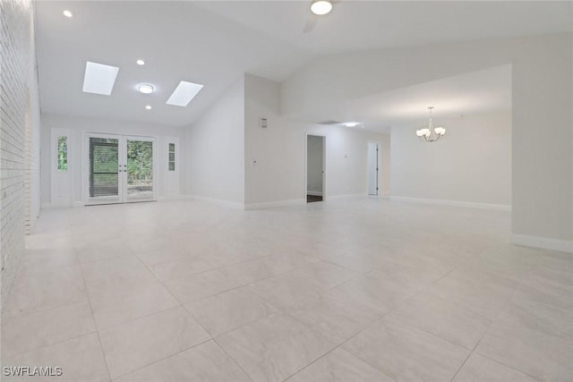 unfurnished living room featuring light tile patterned flooring, a skylight, a chandelier, and high vaulted ceiling