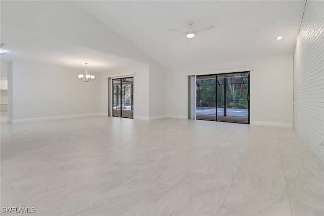 unfurnished room with brick wall, lofted ceiling, and a chandelier