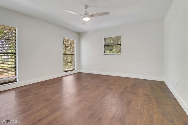 empty room with dark wood-type flooring and ceiling fan