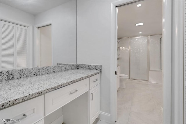 bathroom featuring toilet, vanity, and walk in shower