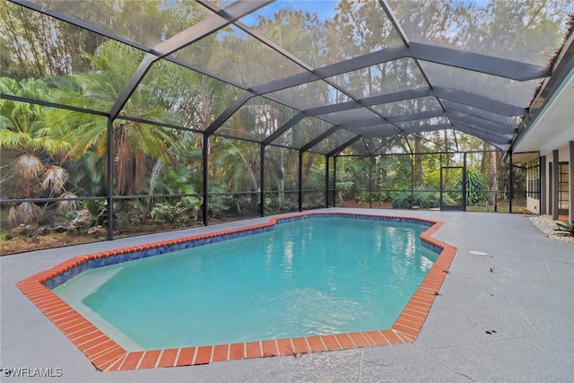 view of swimming pool featuring glass enclosure and a patio area