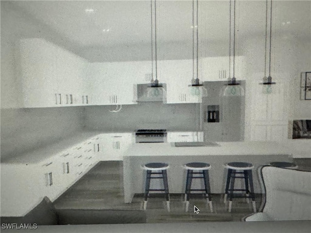 kitchen featuring a breakfast bar, ventilation hood, white cabinets, light stone countertops, and stove