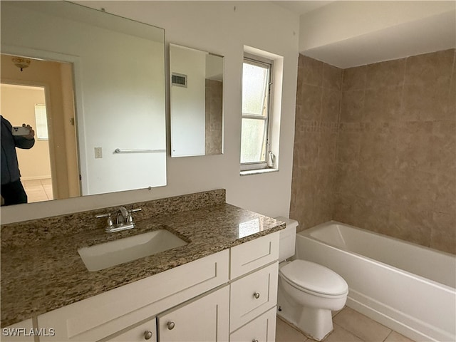 full bathroom with tiled shower / bath, vanity, toilet, and tile patterned flooring