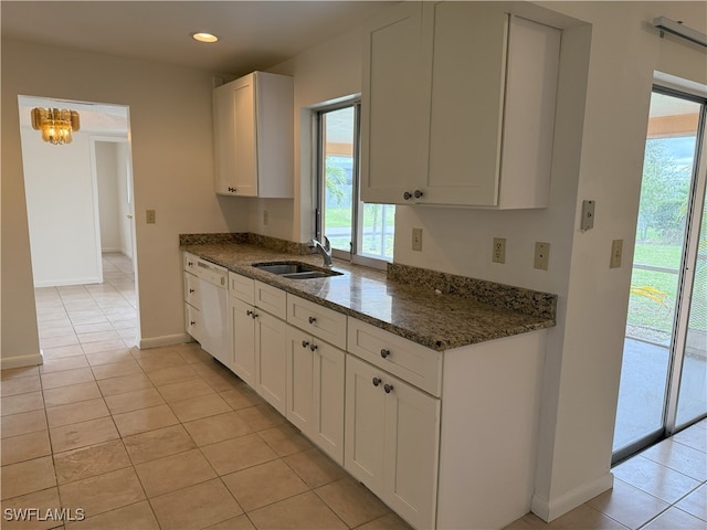 kitchen with white cabinetry, dishwasher, light tile patterned floors, and dark stone counters