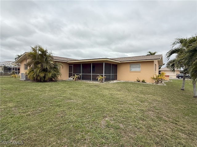 back of property with central AC, a lawn, and a sunroom