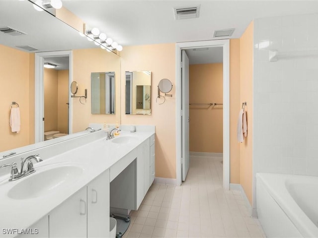 bathroom featuring vanity, a tub, and toilet