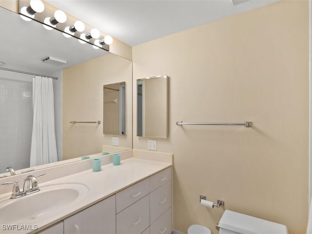 bathroom with vanity, curtained shower, and toilet