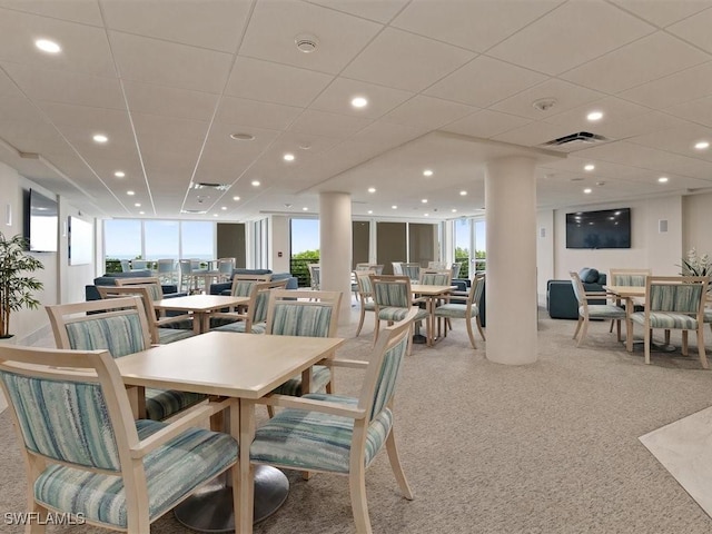 dining space with floor to ceiling windows and light carpet