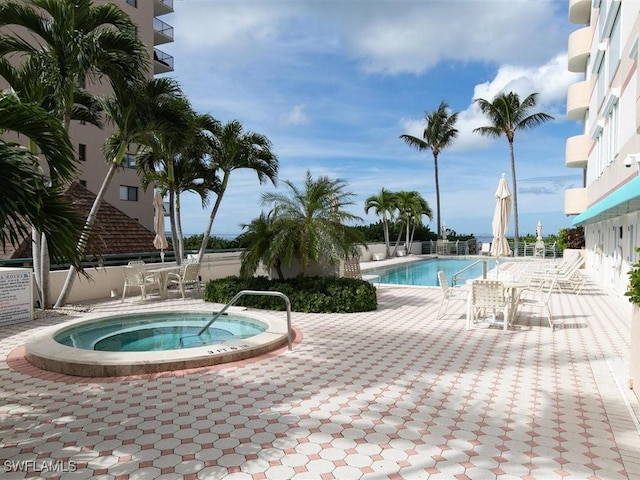 view of pool featuring a hot tub and a patio