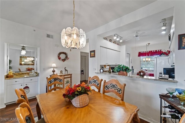 dining room with dark wood-type flooring and ceiling fan with notable chandelier