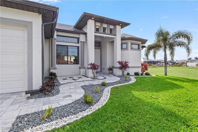 doorway to property with a garage and a yard