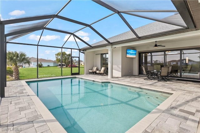 view of pool featuring a patio, a yard, ceiling fan, and glass enclosure