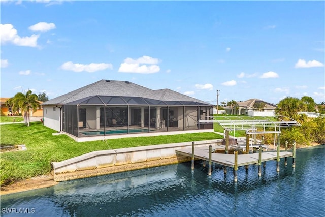 rear view of property featuring a water view, a lanai, and a lawn