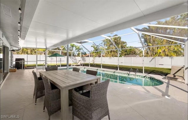 view of pool featuring glass enclosure and a patio area