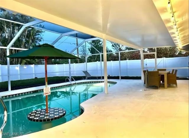 view of swimming pool with glass enclosure and a patio area