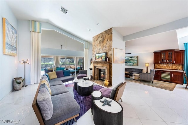 living room featuring vaulted ceiling, light tile patterned floors, and a fireplace