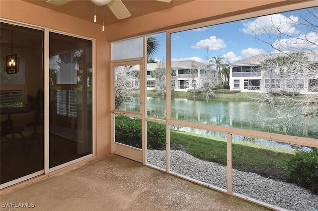 unfurnished sunroom featuring a water view and ceiling fan