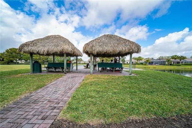 view of community featuring a gazebo, a water view, and a lawn