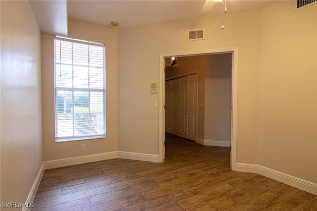 spare room featuring dark wood-type flooring and ceiling fan