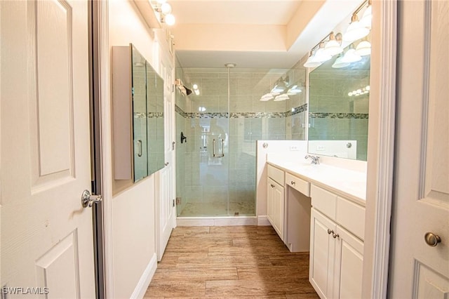 bathroom featuring wood-type flooring, an enclosed shower, and vanity