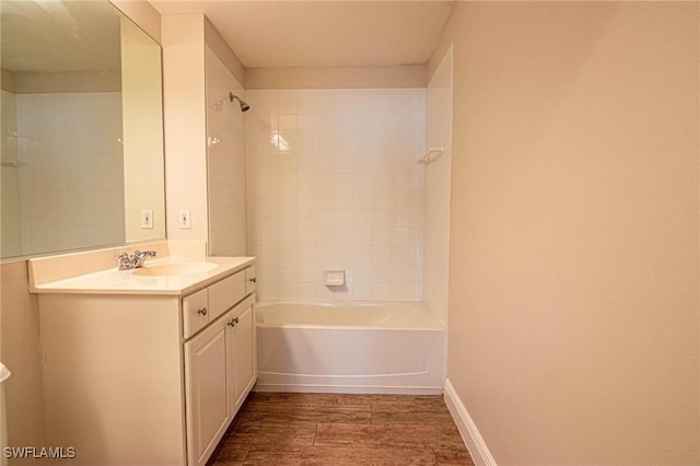 bathroom with vanity, hardwood / wood-style flooring, and tiled shower / bath