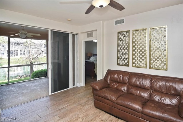 living room featuring ceiling fan and light wood-type flooring