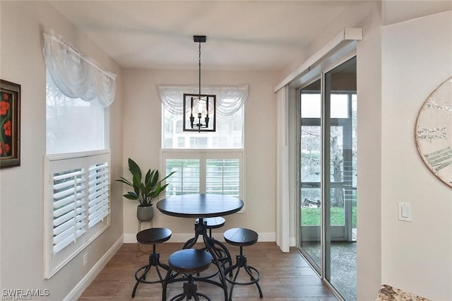 dining area featuring plenty of natural light, dark wood-type flooring, and a chandelier