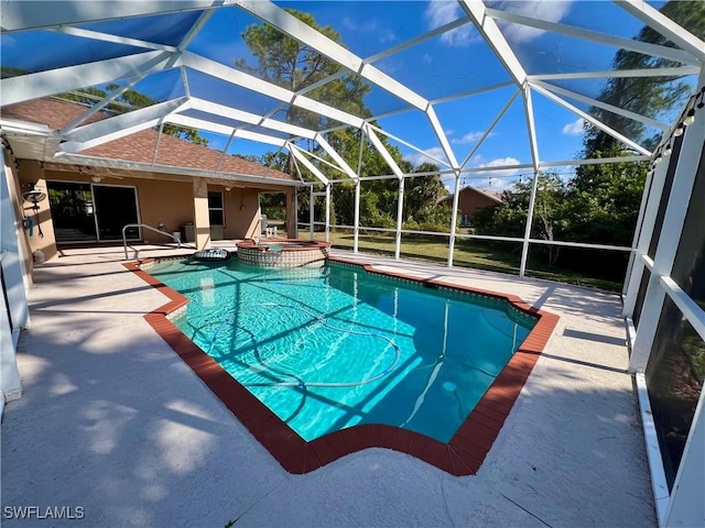 view of swimming pool featuring an in ground hot tub, glass enclosure, and a patio area