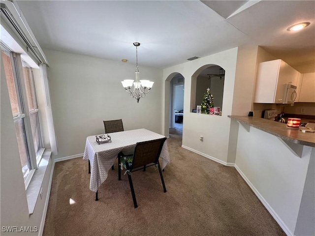 dining room featuring carpet floors and a notable chandelier